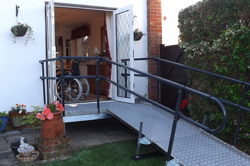 Welcome patio platform fitted in front of double patio doors with ramp and double handrails both sides